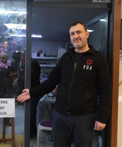 İş yerinin camına astığı "Kefene cep dikilir" yazısıyla ilgi odağı olan esnaf, yazıyı cimrilerin inadına kaldırmıyor