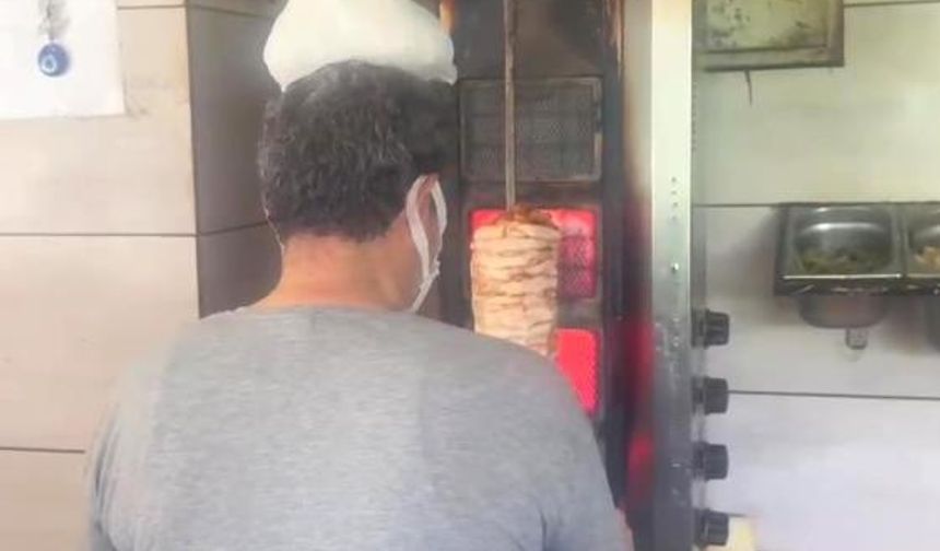 Dönerci ustası kavurucu sıcakta, ateş karşısında kafasına buz torbası koyarak serinlemeye çalıştı