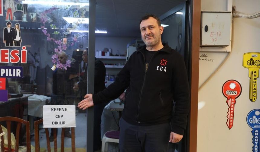 İş yerinin camına astığı "Kefene cep dikilir" yazısıyla ilgi odağı olan esnaf, yazıyı cimrilerin inadına kaldırmıyor